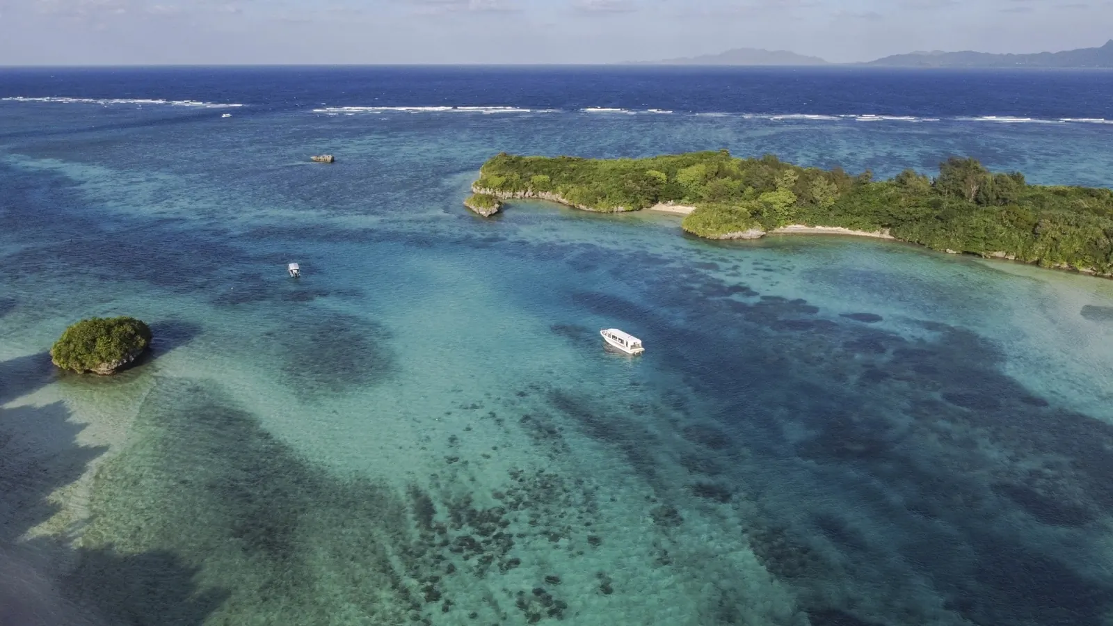 礁湖の観光船と外礁に立つ白波